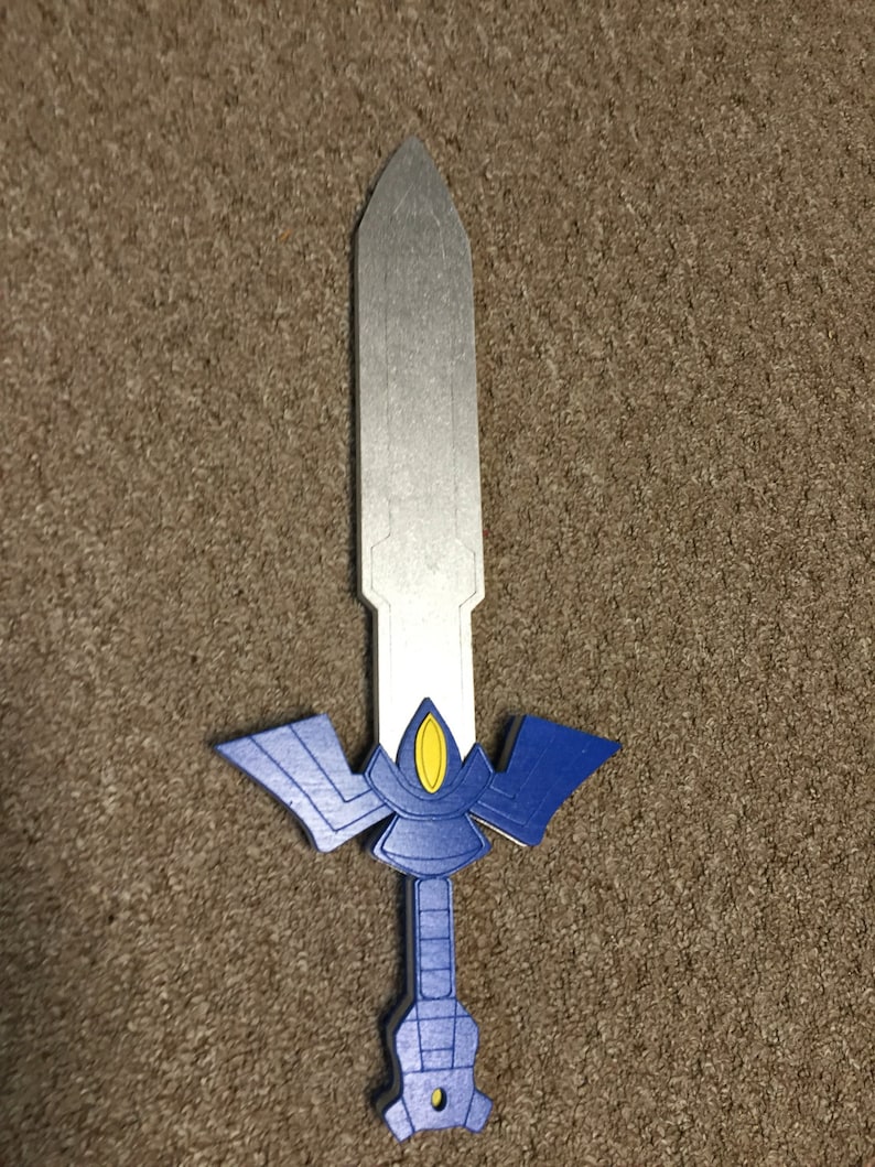 May include: A blue and silver toy sword with a yellow detail. The sword has a pointed tip and a handle with a blue and silver design.