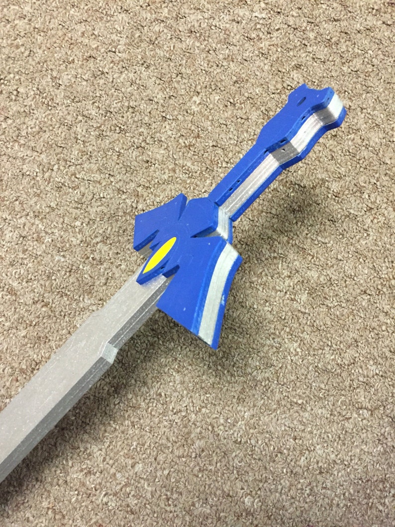 May include: A blue and silver plastic sword with a yellow detail. The sword is made of foam and is a prop.