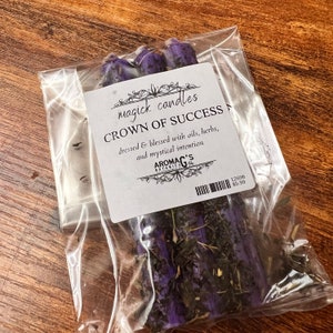 May include: Purple and green magick candles labeled "Crown of Success" dressed and blessed with oils, herbs, and mystical intention. AROMA C'S BOTANICA. 12696 $5.99