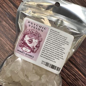 May include: A clear plastic bag containing ritual bath salts. The label reads "Psychic Vision" with an eye graphic and "Aromag's Botanica, Nashville Tennessee". The text on the label describes the use of the bath salts.