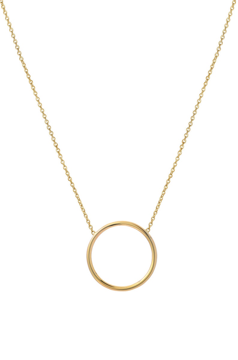 May include: A gold chain necklace with a simple circle pendant.
