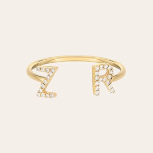 Puede incluir: Un anillo de oro con dos letras, "Z" y "R", engastadas con pequeños diamantes.
