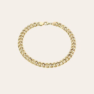 May include: A gold-colored curb chain bracelet. The bracelet features a series of interlocking, rounded links. The clasp and connecting hardware are also gold-toned. The jewelry is displayed against a neutral background.