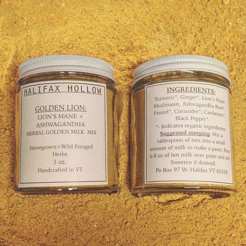 Puede incluir: Dos frascos de vidrio con tapas y etiquetas blancas, llenos de un polvo dorado, sobre una superficie amarilla. Las etiquetas dicen "HALIFAX HOLLOW" y "GOLDEN LION: LION'S MANE + ASHWAGANDHA HERBAL GOLDEN MILK MIX". Una etiqueta enumera los ingredientes.
