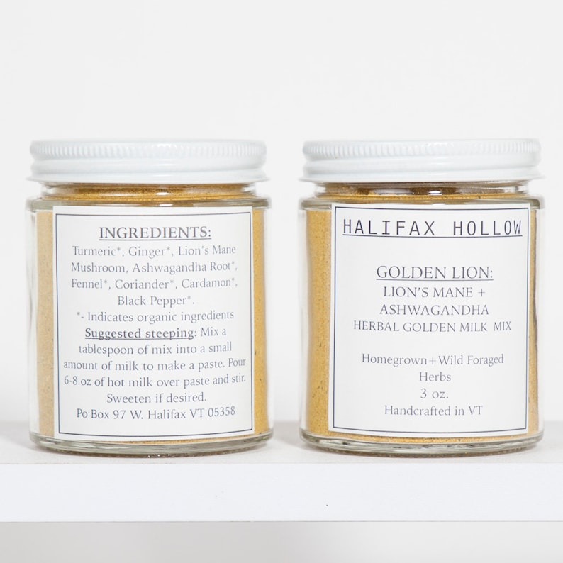 Puede incluir: Dos frascos de vidrio con tapas y etiquetas blancas. Una etiqueta enumera ingredientes como c&uacute;rcuma y jengibre. La otra etiqueta dice "Halifax Hollow Golden Lion Herbal Golden Milk Mix" con "Lion's Mane + Ashwagandha".