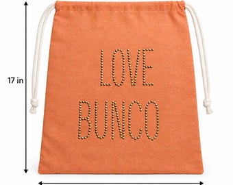 Puede incluir: Una bolsa de cordón naranja con el texto LOVE BUNCO en tachuelas doradas. La bolsa mide 43,18 cm de alto y 34,29 cm de ancho, con cordones blancos a ambos lados para cerrarla y transportarla.