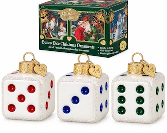 Puede incluir: Un juego de tres adornos navideños de cristal en forma de dados blancos con bordes brillantes, cada uno con una tapa dorada y un dije en forma de corazón grabado con la palabra Joy. Los dados tienen puntos rojos, azules y verdes, presentados en una caja verde.