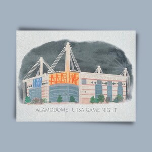 May include: A watercolor painting of the Alamodome, a large stadium with a dark gray sky in the background. The text "ALAMODOME | UTSA GAME NIGHT" is written below the stadium.