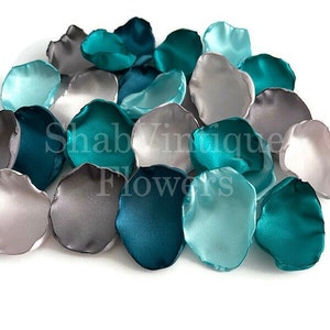 Op de afbeelding: Turquoise, grijs en lichtblauwe satijnen bloemblaadjes. Deze bloemblaadjes zijn perfect voor bruiloftsdecoratie, om te strooien in de gang of om een ​​toets van elegantie toe te voegen aan elk evenement.