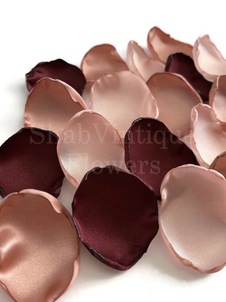 Puede incluir: Una colecci&oacute;n de p&eacute;talos de flores artificiales en tonos burdeos intenso y rosa suave. Los p&eacute;talos tienen una textura lisa similar al sat&eacute;n con bordes curvos y un ligero brillo. El texto ShabVintique flowers est&aacute; superpuesto en la imagen.