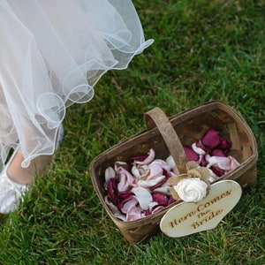 May include: A wooden basket filled with pink and burgundy flower petals. A sign attached to the basket reads "Here Comes The Bride".