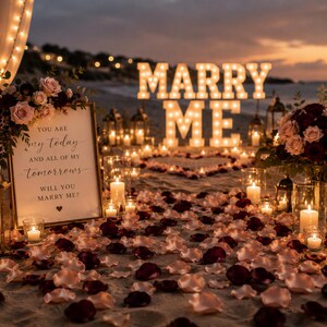 Puede incluir: Un montaje de propuesta de matrimonio en la playa con letras luminosas grandes que forman MARRY ME, un letrero enmarcado con el texto YOU ARE my today AND ALL OF MY tomorrows WILL YOU MARRY ME?, p&eacute;talos de rosa rojos y rosas, y velas.