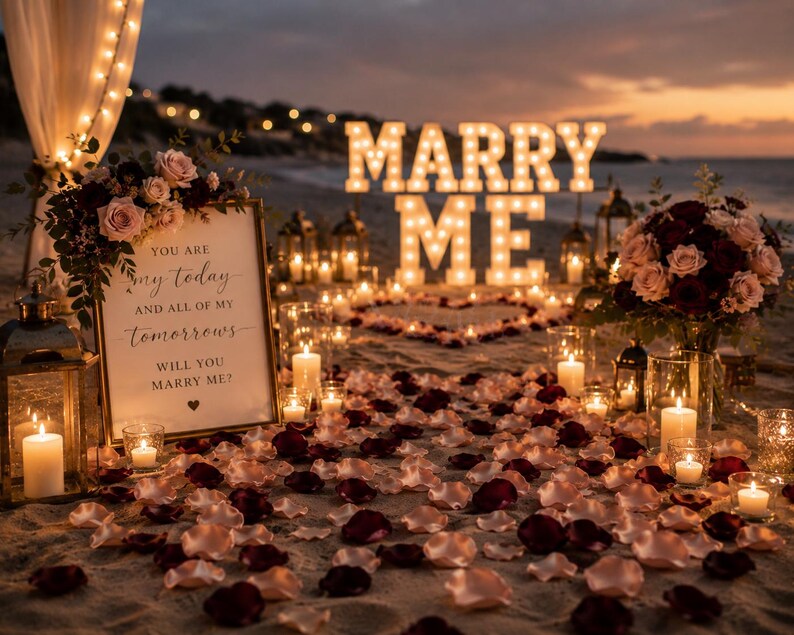 Puede incluir: Un montaje de propuesta de matrimonio en la playa con letras luminosas grandes que forman MARRY ME, un letrero enmarcado con el texto YOU ARE my today AND ALL OF MY tomorrows WILL YOU MARRY ME?, p&eacute;talos de rosa rojos y rosas, y velas.