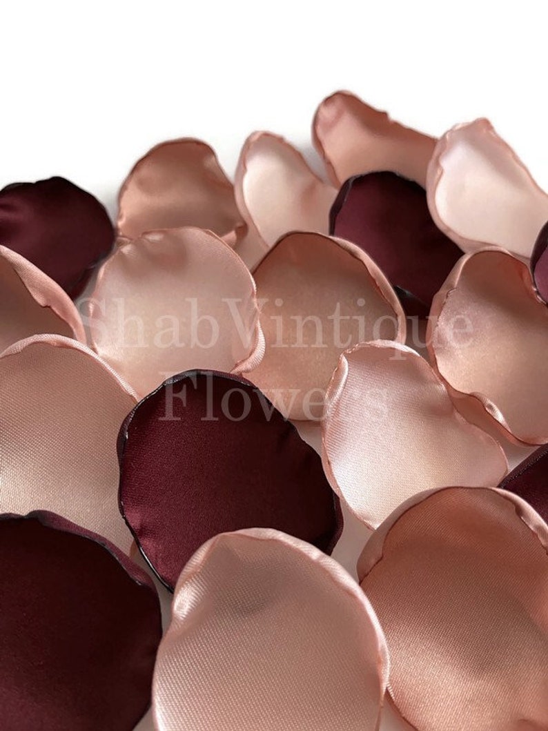 Puede incluir: Una colecci&oacute;n de p&eacute;talos de flores artificiales en tonos burdeos intenso y rosa rubor suave. Los p&eacute;talos tienen una textura suave y satinada con bordes redondeados. El texto ShabVintique Flowers est&aacute; superpuesto en blanco en el centro.
