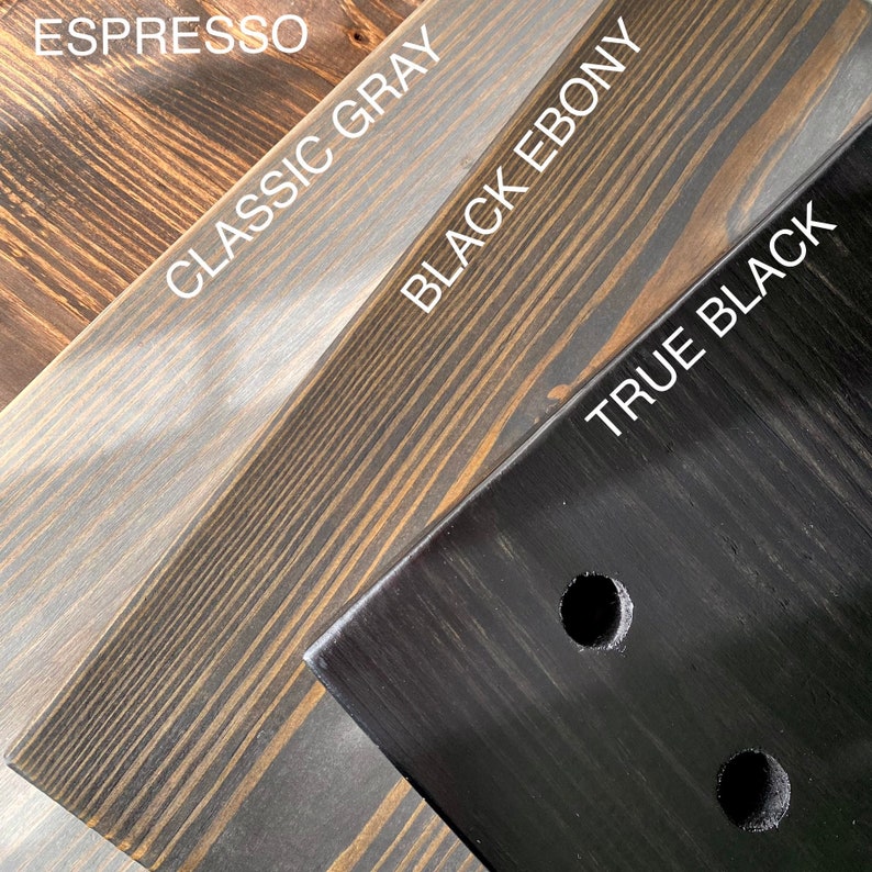 Puede incluir: Cuatro tablas de madera que muestran diferentes acabados de tinte etiquetados como Espresso, Classic Gray, Black Ebony y True Black. La veta de la madera es visible en cada pieza, y la tabla True Black tiene dos orificios circulares perforados.