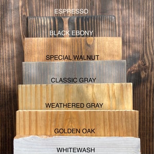 Puede incluir: Una pila de seis tablas de madera rectangulares que muestran varios acabados de tinte etiquetados como Espresso, Black Ebony, Special Walnut, Classic Gray, Weathered Gray, Golden Oak y Whitewash. Cada tabla muestra patrones de veta.