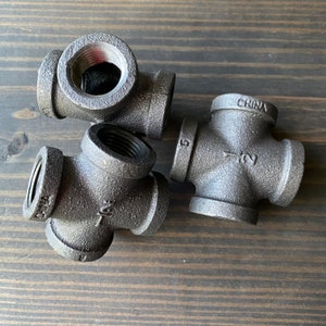 May include: Three black iron pipe fittings, two are 4-way cross fittings and one is a 90-degree elbow fitting. The cross fittings have the text "1/2" and "CHINA" printed on them.