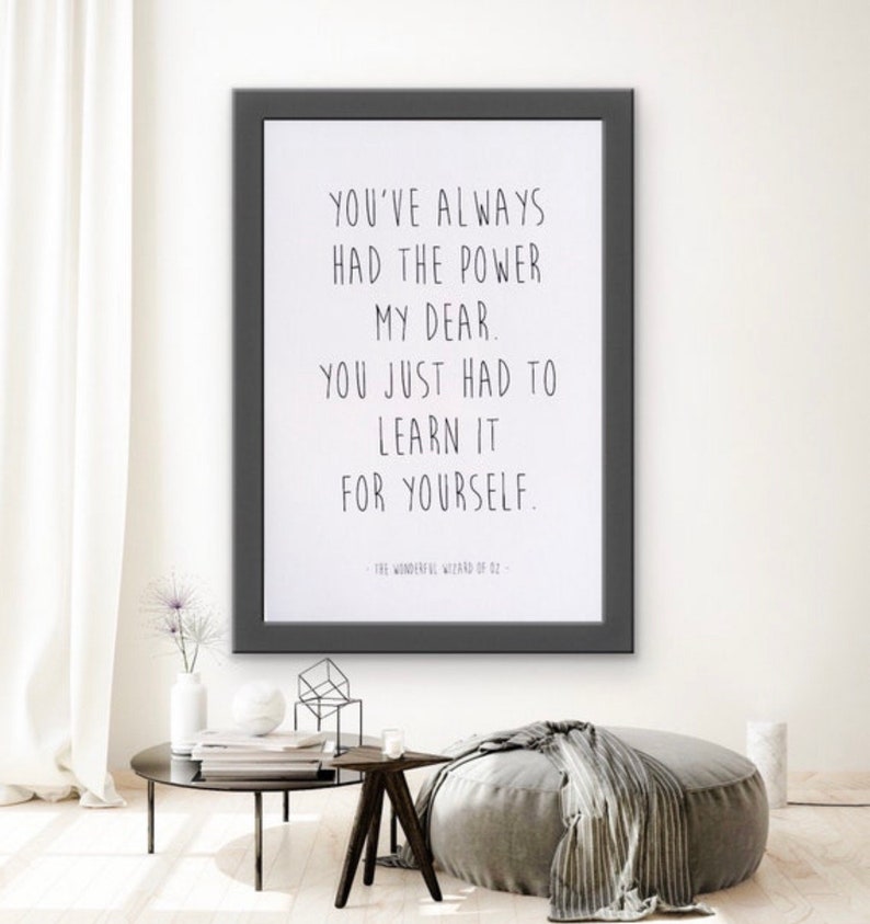 May include: A black framed print with a white background and a quote from The Wonderful Wizard of Oz: "You've always had the power my dear. You just had to learn it for yourself."