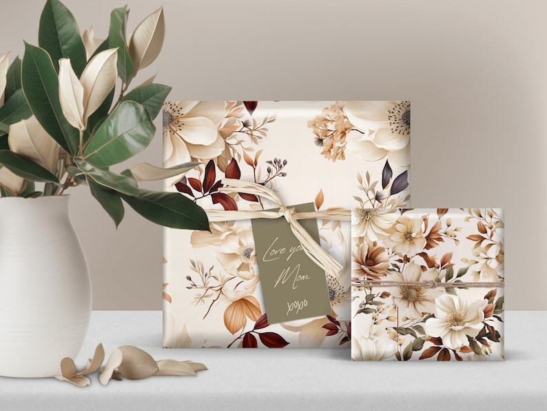 May include: Two gift boxes wrapped in white paper with a floral pattern in shades of brown, cream, and beige. The larger box has a brown tag with the text "Love you Mom xoxo".