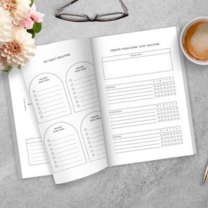 May include: A white planner with a black and white design. The planner has sections for "My Daily Routine" and "Create Your Own "XYZ" Routine".