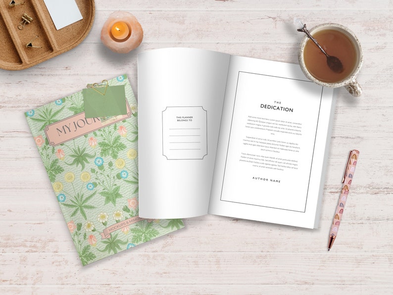 May include: A green journal with a floral pattern and the text "My Journal" on the cover. The journal is open to a blank page with a dedication page on the right side. The dedication page has the text "The Dedication" and "Author Name".