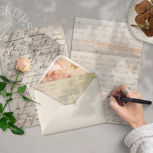 May include: A white envelope with a pink rose design on the front. The envelope is open and there is a handwritten letter inside. The letter is on a table with a pen and a hand writing on it.