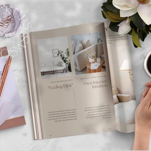 May include: Open magazine with a beige cover featuring the text "Feeling First" and "Own Interior Intuition". The magazine is on a white marble surface with a cup of coffee, a notepad, a pen, and a flower.