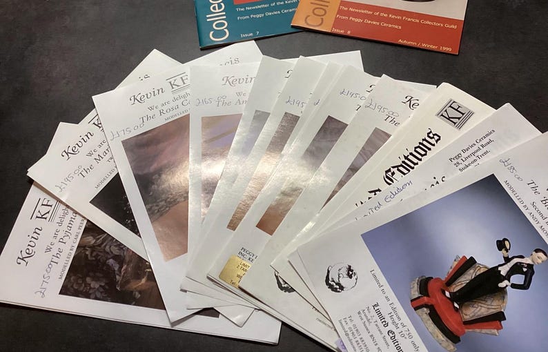 May include: A selection of printed ephemera, including brochures and newsletters, are fanned out on a dark surface. The publications feature the text "Kevin KF" and "Editions", with images and text. Some have handwritten prices.