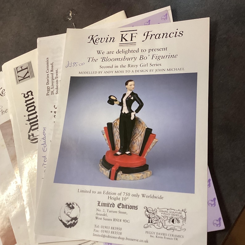 May include: A ceramic figurine of a person in formal wear, holding a hat, on a decorative base. The figurine is part of the 'Ritzy Girl Series' and is 25.4 cm tall. The image includes promotional materials from 'Peggy Davies Ceramics'.