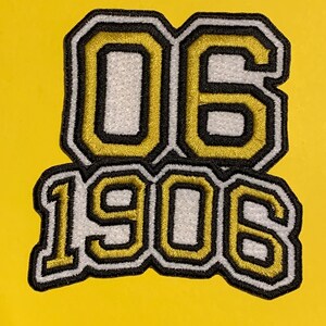May include: A yellow patch with the numbers "06" above "1906". The numbers are white with a gold outline and black border. The background is a solid yellow.