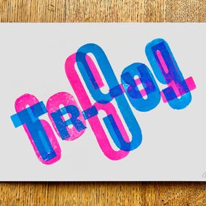 May include: A print of the word "today" in overlapping blue and pink letters. The letters are stacked on top of each other, creating a layered effect.