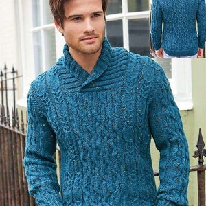 Può includere: Un maglione di lana blu turchese con un motivo a treccia e un collo largo.