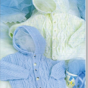 May include: Two knitted baby jackets with hoods, one in light blue and one in white with blue flecks. Both jackets feature a cable knit pattern and button closures. The text "DOUBLE KNITTING" is visible at the top of the image.