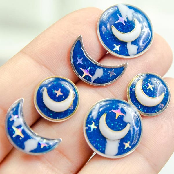 Glow-in-the-dark celestial studs — mix and match moons and stars, hand-painted twilight skies on hypoallergenic titanium