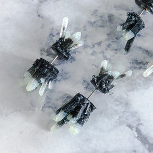 May include: Three pairs of black and white crystal-shaped earrings. Each earring features a cluster of white crystals on a black base.