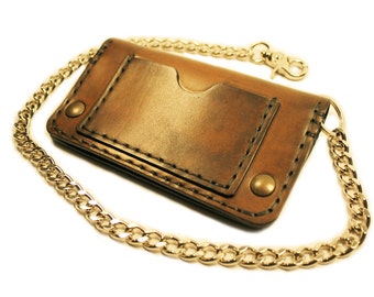 May include: A brown leather wallet with a gold chain attached. The wallet has a single card slot and a snap closure.