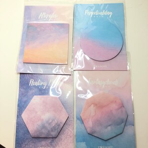 May include: Four packs of colorful sticky notes with different shapes and designs. Each pack features a different watercolor-style sky with a title: Afterglow, Perpetualday, Floating Moon, and Fantasyclouds. Each pack also includes the word "TWILIGHT" and a small graphic.