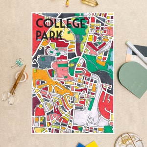 May include: A colorful, hand-drawn map print of College Park, featuring a vibrant mix of red, yellow, green, and orange. The print includes street names and the words "COLLEGE PARK" in bold black letters at the top. The artwork is on a white background.
