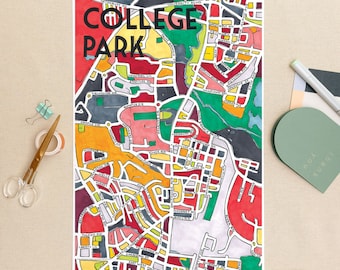 Puede incluir: Una colorida impresión de mapa dibujada a mano de College Park, con una vibrante mezcla de rojo, amarillo, verde y naranja. La impresión incluye nombres de calles y las palabras "COLLEGE PARK" en letras negras en negrita en la parte superior. La obra de arte está sobre un fondo blanco.