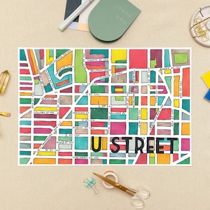 May include: A colorful hand-drawn map of a neighborhood called "U Street" with street names and blocks outlined in different colors. The map is drawn on a white background.