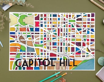 May include: A colorful hand-drawn map of Capitol Hill in Washington, D.C. The map features a grid of streets and avenues, with different colored blocks representing different neighborhoods. The text "CAPITOL HILL" is written in bold black letters at the bottom of the map.