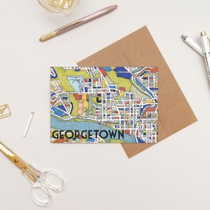 May include: A colorful illustrated map of Georgetown, a neighborhood in Washington, D.C. The map is printed on a white card with the word "GEORGETOWN" printed in black at the bottom.