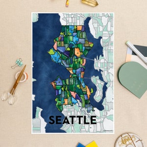 May include: A colorful map of Seattle, Washington, with each neighborhood outlined and labeled. The map is on a blue background with a white border. The word "Seattle" is printed in black at the bottom of the map.