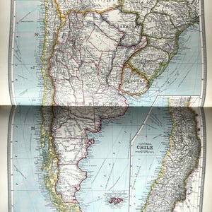 Może przedstawiać: Ręcznie robiony drewniany znak z napisem "Welcome to our home" w stylu odręcznym. Znak jest pomalowany na biało z ciemną, bejcowaną drewnianą ramą. Mała zielona roślina jest umieszczona na znaku.