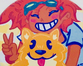 May include: A round button featuring a cartoon illustration of a person with red hair wearing goggles and a blue shirt, holding a peace sign with their left hand and a smiling orange dog with brown eyes and a pink tongue.