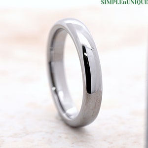 May include: A silver tungsten carbide ring with a polished finish. The ring is simple and elegant, and it is perfect for a wedding band or an everyday ring.