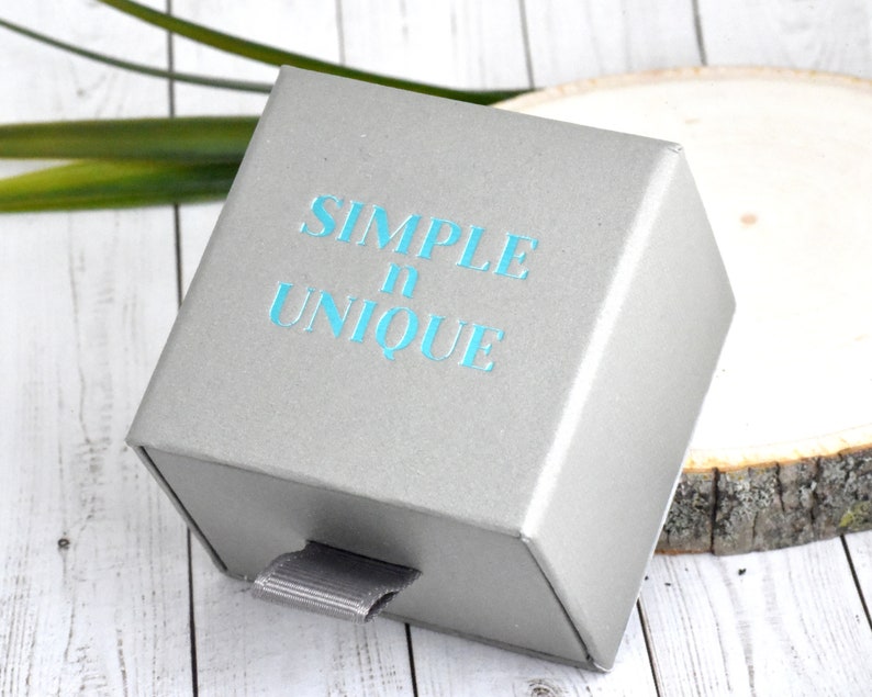May include: A gray gift box with a drawer. The box has the text "SIMPLE & UNIQUE" printed on the front in blue.