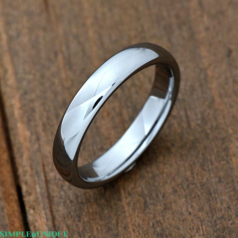 May include: A simple silver-toned wedding band with a brushed finish.