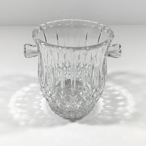 May include: A clear glass ice bucket with two handles. The bucket has a diamond pattern.