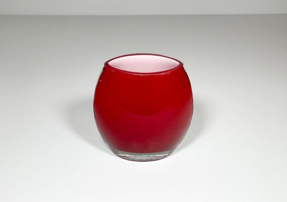 A hand-blown crystal art glass vase shaped like a football — the red-white casing technique is a classic glassblowing craft that's genuinely rare to stumble across.
